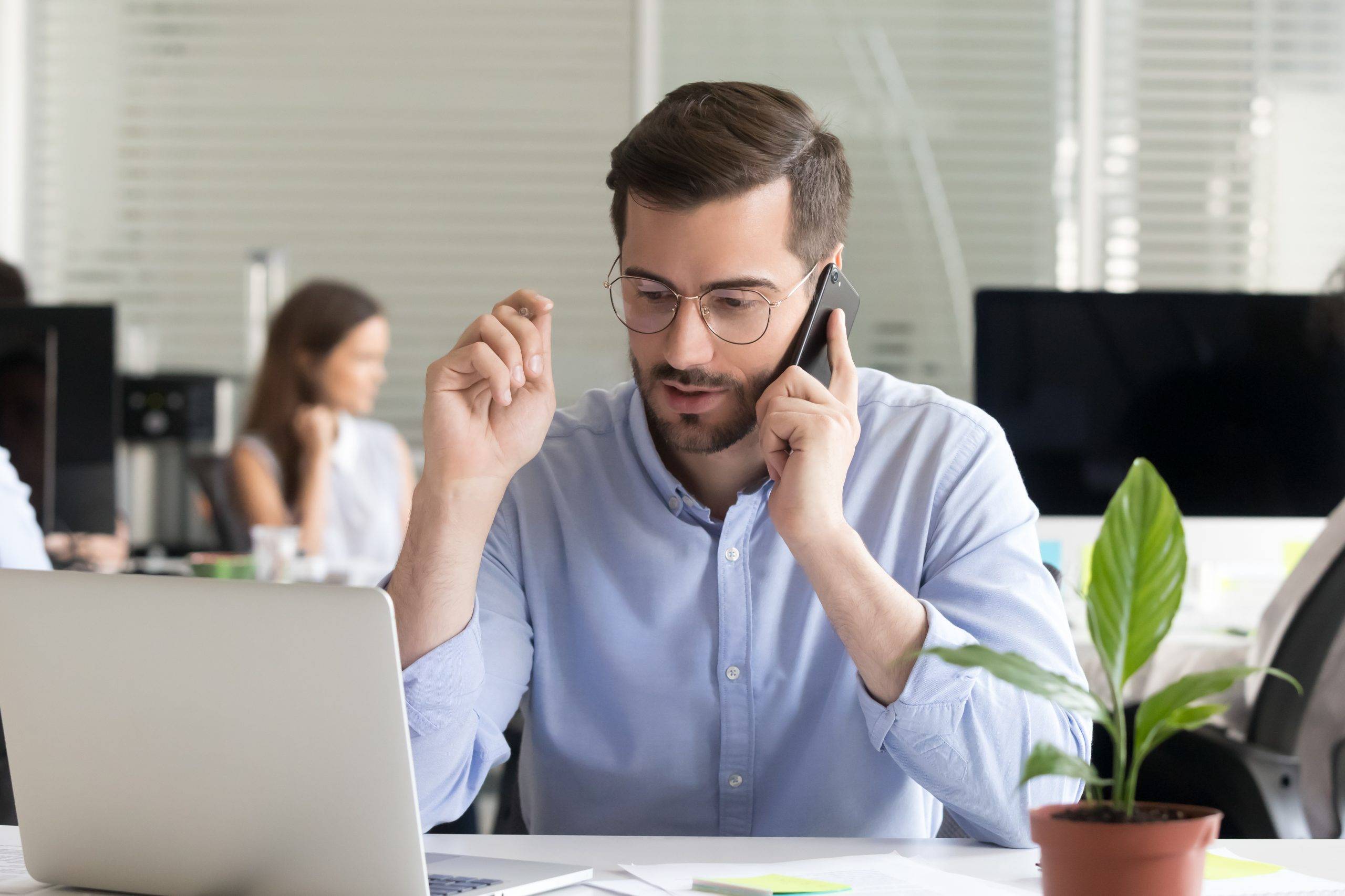 Sales manager consulting client talking on phone in office